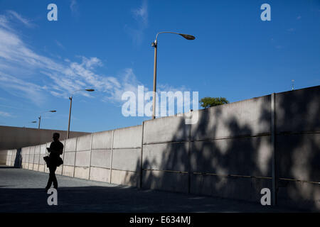 Berlin, Germany. 13th Aug, 2014. A visitor walks past a section of the Berlin Wall at the Berlin Wall Memorial in Berlin, Germany, 13 August 2014. The Berlin Wall was constructed 53 years ago to the day, on 13 August 1961. The day was commemorated with a service and a wreath ceremony. PHOTO: JOERG CARTSENSEN/dpa/Alamy Live News Stock Photo