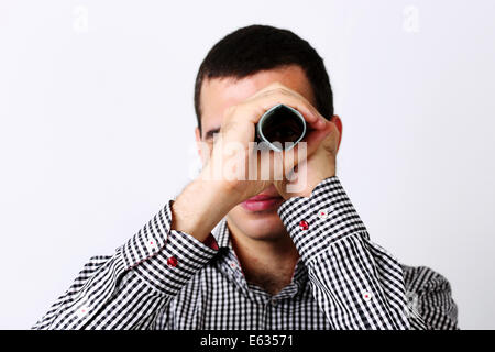 Businessman looks at camera through tube from dollars Stock Photo