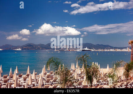 Beach sun loungers and sun umbrellas wait for the days tourist on Cannes beach Stock Photo