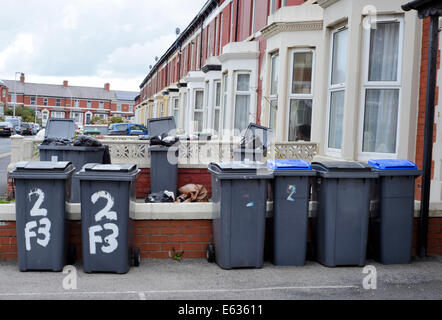 Several overflowing wheelie bins outside a house in a suburban street Stock Photo