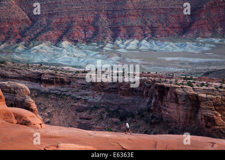 Hiker on cliff edge near Delicate Arch, Arches National Park, near Moab, Utah, USA Stock Photo