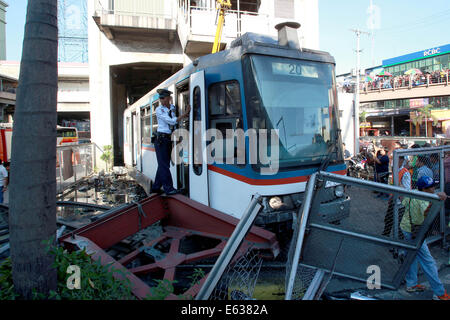 Pasay City, Philippines. 13th Aug, 2014. A security guard stands in front of the door of a derailed train coach in Pasay City, the Philippines, on Aug. 13, 2014. Around 20 passengers were injured after a train of the Metro Rail Transit(MRT) derailed and slammed into the concrete barrier of an MRT station in Pasay City in the Philippine capital region of Metro Manila on Wednesday afternoon. Credit:  Rouelle Umali/Xinhua/Alamy Live News Stock Photo