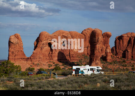 Unusual rock formations and RV in carpark at The Windows Section, Arches National Park, near Moab, Utah, USA Stock Photo
