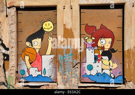 Colorful graffiti artwork happy cartoon figures on boarded up windows. Youth culture urban street art.