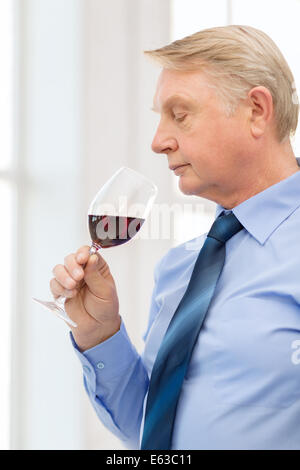 older man smelling red wine Stock Photo