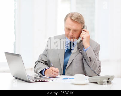 busy older businessman with laptop and telephone Stock Photo