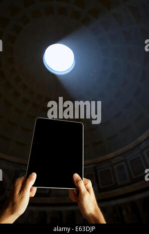 Hands of tourist holding digital tablet computer under the dramatic dome of the Pantheon Rome Italy Stock Photo