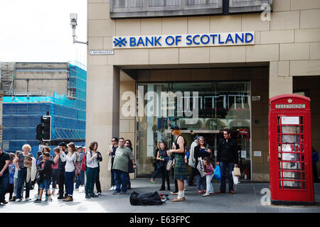 Scotland 2014. Edinburgh  Festival. Street entertainer wearing a kilt outside the Royal Bank of Scotland, the Lawnmarket Stock Photo