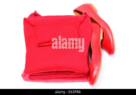 Leather shoes of woman and pile of red shirts and clothes. Isolated on white background Stock Photo