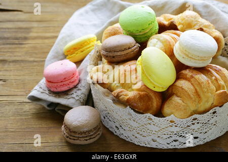 traditional French pastries croissants and macaroons in a lace basket Stock Photo