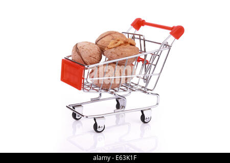 Walnuts in miniature shopping cart isolated on white background Stock Photo
