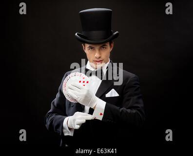 magician showing trick with playing cards Stock Photo