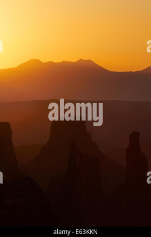 Sunrise over La Sal Mountains, Washer Woman Arch, Monster tower, and Airport Tower, from Mesa Arch, Island in the Sky district, Stock Photo