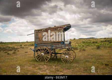 An old west sheriff's wagon sits on the lonesome frontier prairie as storm clouds gather in the distance. Stock Photo