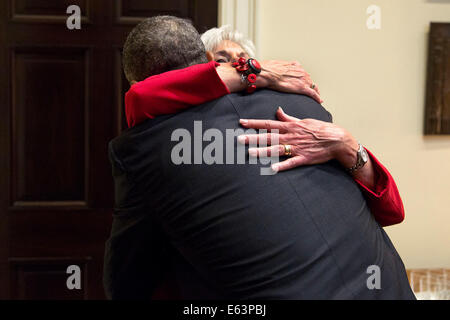 President Barack Obama hugs outgoing Health and Human Services Secretary Kathleen Sebelius before she departs an Affordable Care Act update meeting in the Roosevelt Room of the White House, May 15, 2014. Stock Photo