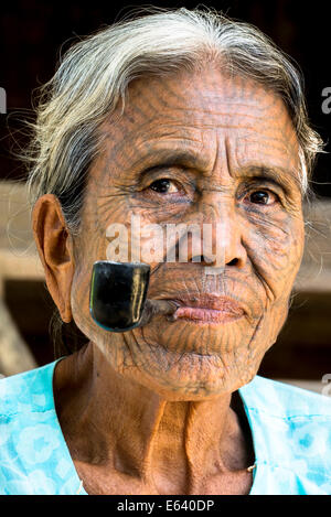 Woman of the Chin people, ethnic minority, with a traditional facial tattoo smoking a pipe, the last of their kind, portrait Stock Photo