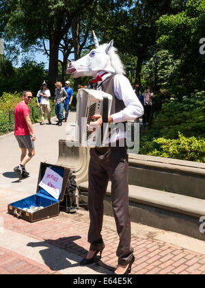 Unicorn Impersonator Playing the Accordion at Bethesda Plaza in Central Park, NYC Stock Photo