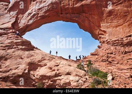 Tourists stand in the North Window Arch. Arches National Park, Utah, USA.