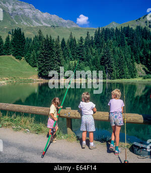 Children angling at Les Mines d'Or lake Morzine resort Savoy French Alps France Stock Photo