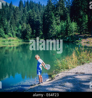 Boy angling at Les Mines d'Or lake Morzine resort Savoy French Alps France Stock Photo