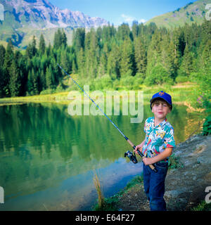 Little boy angling at Les Mines d'Or lake Morzine resort Savoy French Alps France Europe Stock Photo