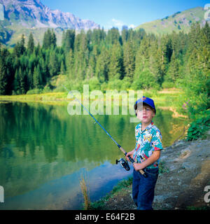 Little boy angling at Les Mines d'Or lake Morzine resort Savoy French Alps France Stock Photo