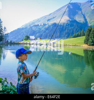 Little boy angling at Les Mines d'Or lake Morzine resort Savoy French Alps France Stock Photo