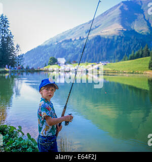 Little boy angling at Les Mines d'Or lake Morzine resort Savoy French Alps France Stock Photo