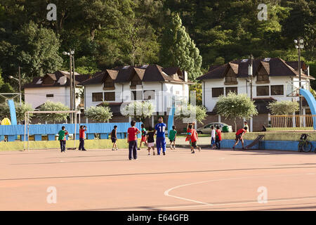 BANOS, ECUADOR - FEBRUARY 26, 2014: Unidentified children playing football on public pitch along Montalvo Street in Banos. Stock Photo