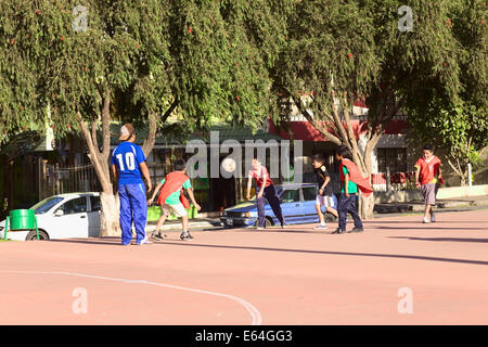 BANOS, ECUADOR - FEBRUARY 26, 2014: Unidentified children playing football on public pitch in Banos, Ecuador Stock Photo