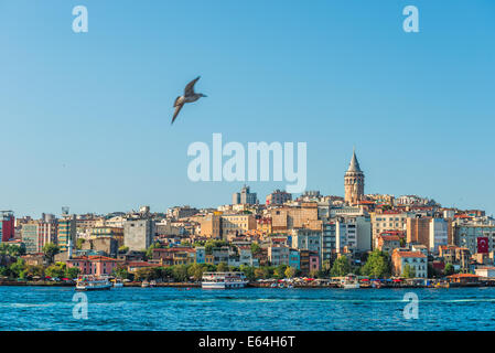 A ferry passes along the Bosphorus with Galata Tower in the distance. Stock Photo