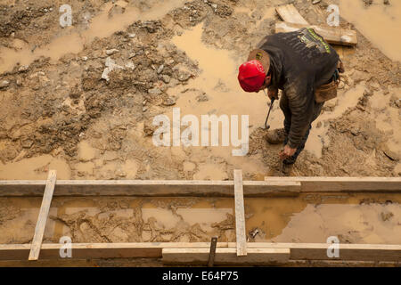 Worker hammers frame for the foundation of a residential building in the Berkshires of Massachusetts. Stock Photo