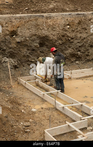 Workers check level as they frame the foundation of a residential building in the Berkshires of Massachusetts. Stock Photo