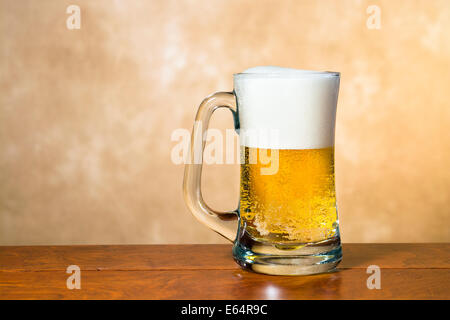 A cold, crisp mug of beer in a traditional pint glass with a foamy head Stock Photo