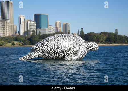 Sydney, NSW 2000, Australia. 15 August 2014. To celebrate the opening of World's first Undersea Art Exhibition at Sydney Aquarium a giant 15m floating sea turtle sculpture appeared on Sydney Harbour – viewed from near Mrs Macquarie's Chair, with SYdney Botanic Gardens and teh Central Business District in teh background. Copyright Credit:  2014 Richard Milnes/Alamy Live News. Stock Photo