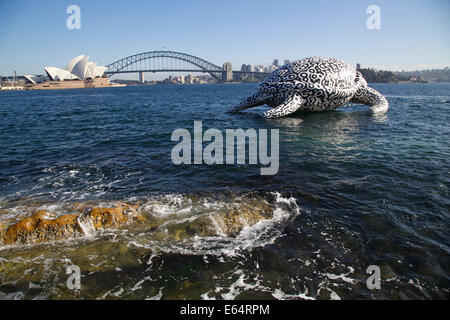 Sydney, NSW 2000, Australia. 15 August 2014. To celebrate the opening of World's first Undersea Art Exhibition at Sydney Aquarium a giant 15m floating sea turtle sculpture appeared on Sydney Harbour – viewed from near Mrs Macquarie's Chair.. The Sydney Opera House and Sydney Harbour Bridge are in the background. Copyright Credit:  2014 Richard Milnes/Alamy Live News. Stock Photo