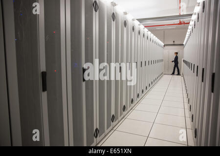 Technician walking in server hallway Stock Photo