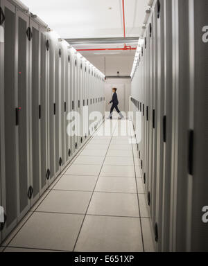 Technician walking in server hallway Stock Photo
