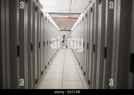Technician walking in server hallway Stock Photo