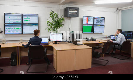 Technicians sitting in office running diagnostics Stock Photo