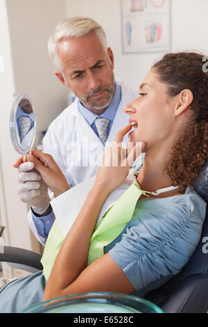 Patient showing dentist the problem in the mirror Stock Photo