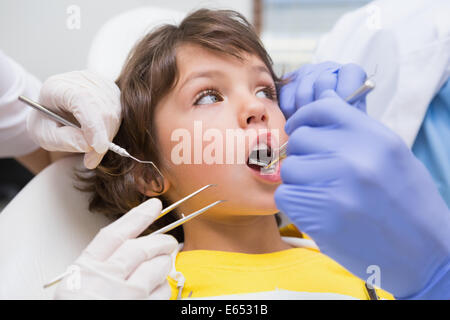 Pediatric dentist examining a little boys teeth with his assistant Stock Photo