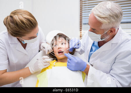 Pediatric dentist examining a little boys teeth with his assistant Stock Photo