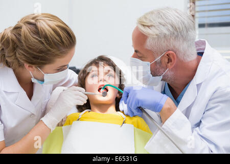 Pediatric dentist examining a little boys teeth with his assistant Stock Photo