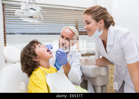 Pediatric dentist examining a little boys teeth with his assistant Stock Photo