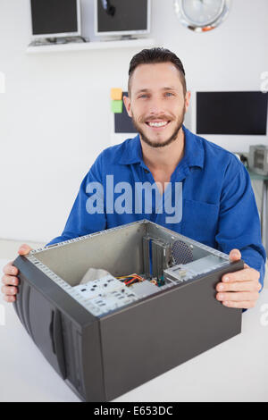 Computer engineer sitting with open computer smiling at camera Stock Photo