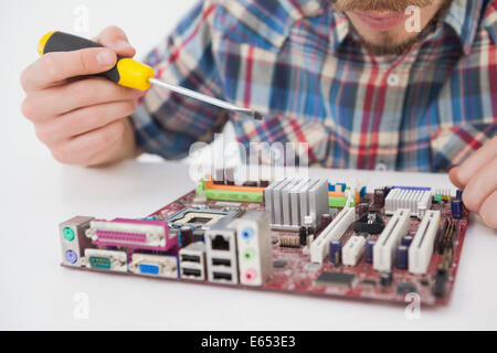 Computer engineer working on cpu with screwdriver Stock Photo