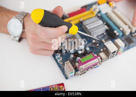 Computer engineer working on cpu with screwdriver Stock Photo