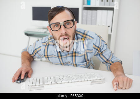 Nerdy stressed businessman working on computer Stock Photo