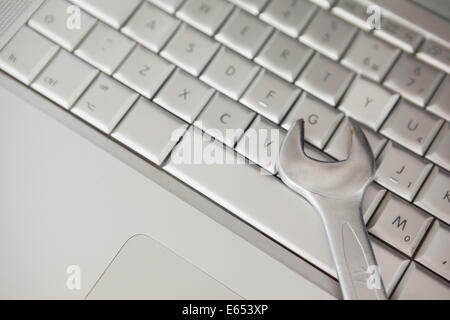 Pliers lying on silver keyboard Stock Photo